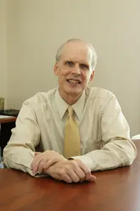 A man sitting at a table wearing a tie.