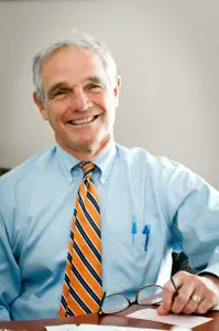 A man in a blue shirt and orange tie.